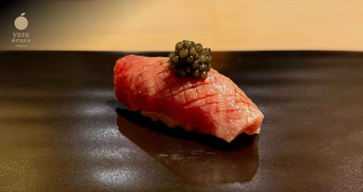 a piece of raw meat with a black caviar on top